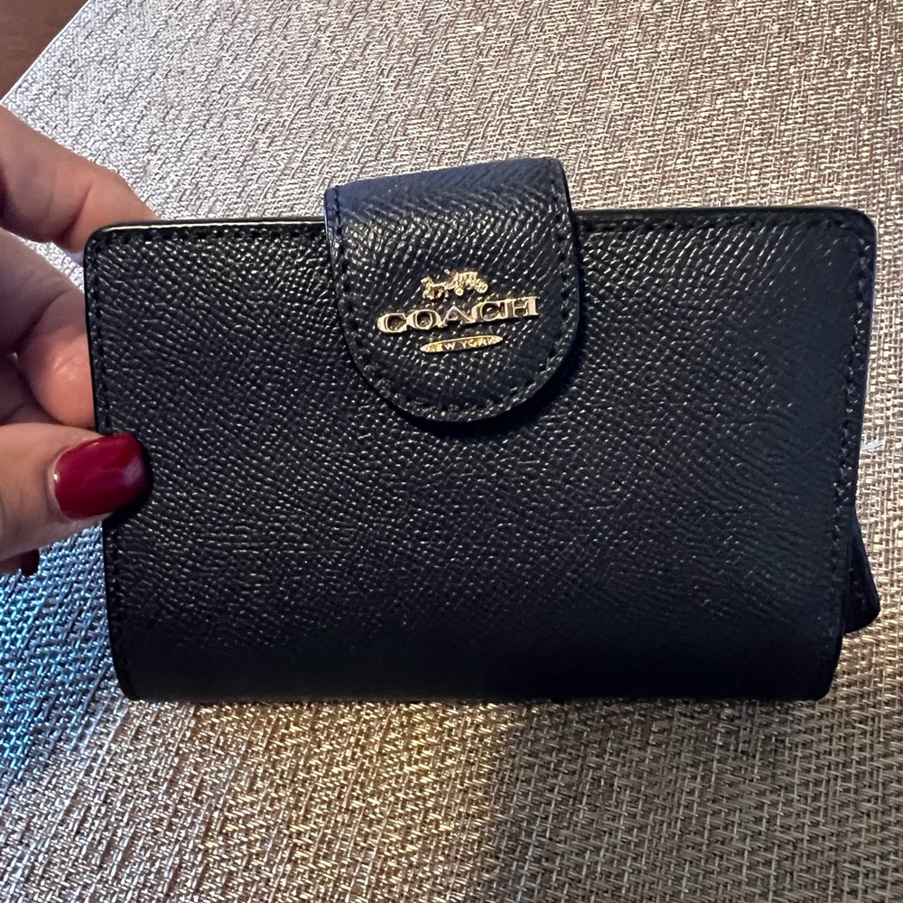 Like new - only used once. Sturdy leather navy blue Coach medium wallet.